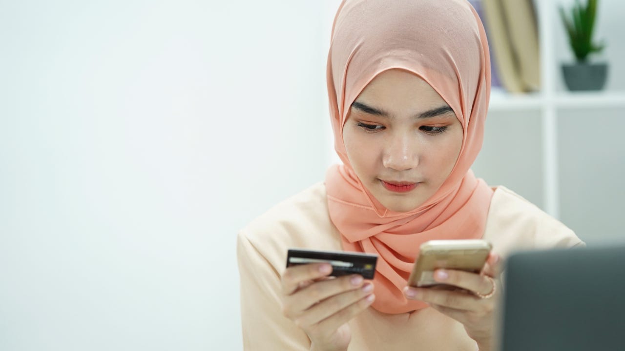 Person looking at credit card and cellphone