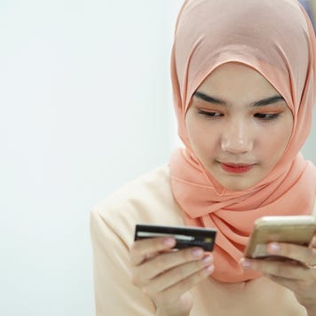 Person looking at credit card and cellphone