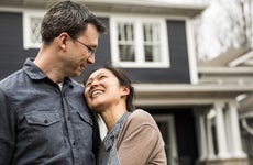 Couple standing in front of home