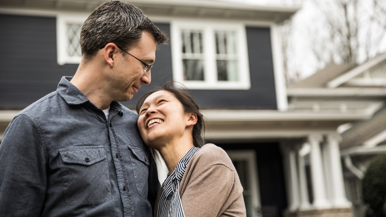 Couple standing in front of home