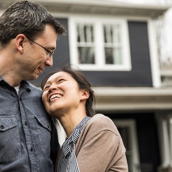 Couple standing in front of home