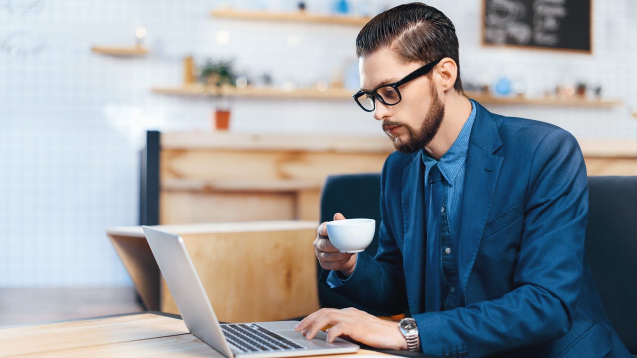 Man works on laptop at a cafe