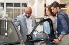 Couple looks at a car at a dealership