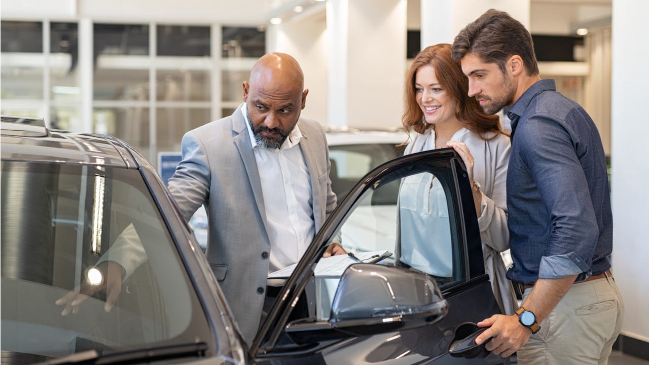 Couple looks at a car at a dealership