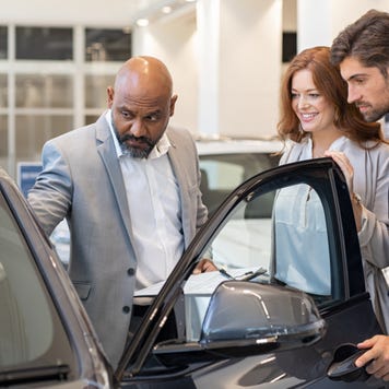 Couple looks at a car at a dealership