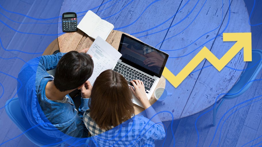 A couple looks over their financial statements with a laptop