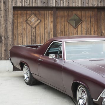 A vintage car parked in front of a house.