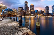 View of the Boston skyline at night from the coast of the harbor.