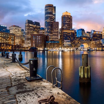 View of the Boston skyline at night from the coast of the harbor.