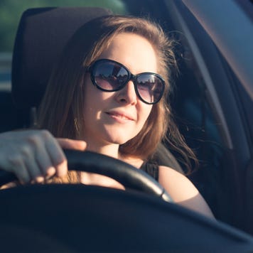 Woman wearing sunglasses drives a car