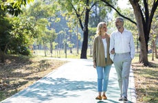 Older couple walking together in a park.