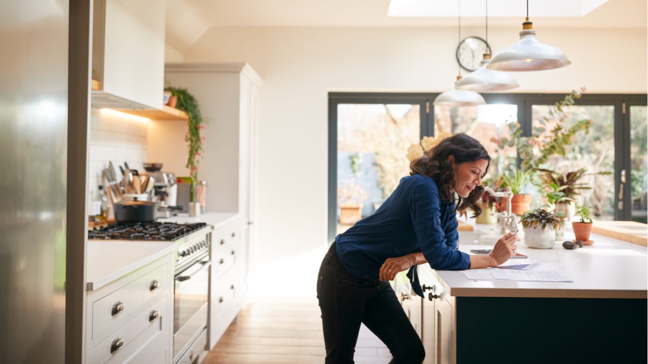 Woman works on paperwork in a kitchen