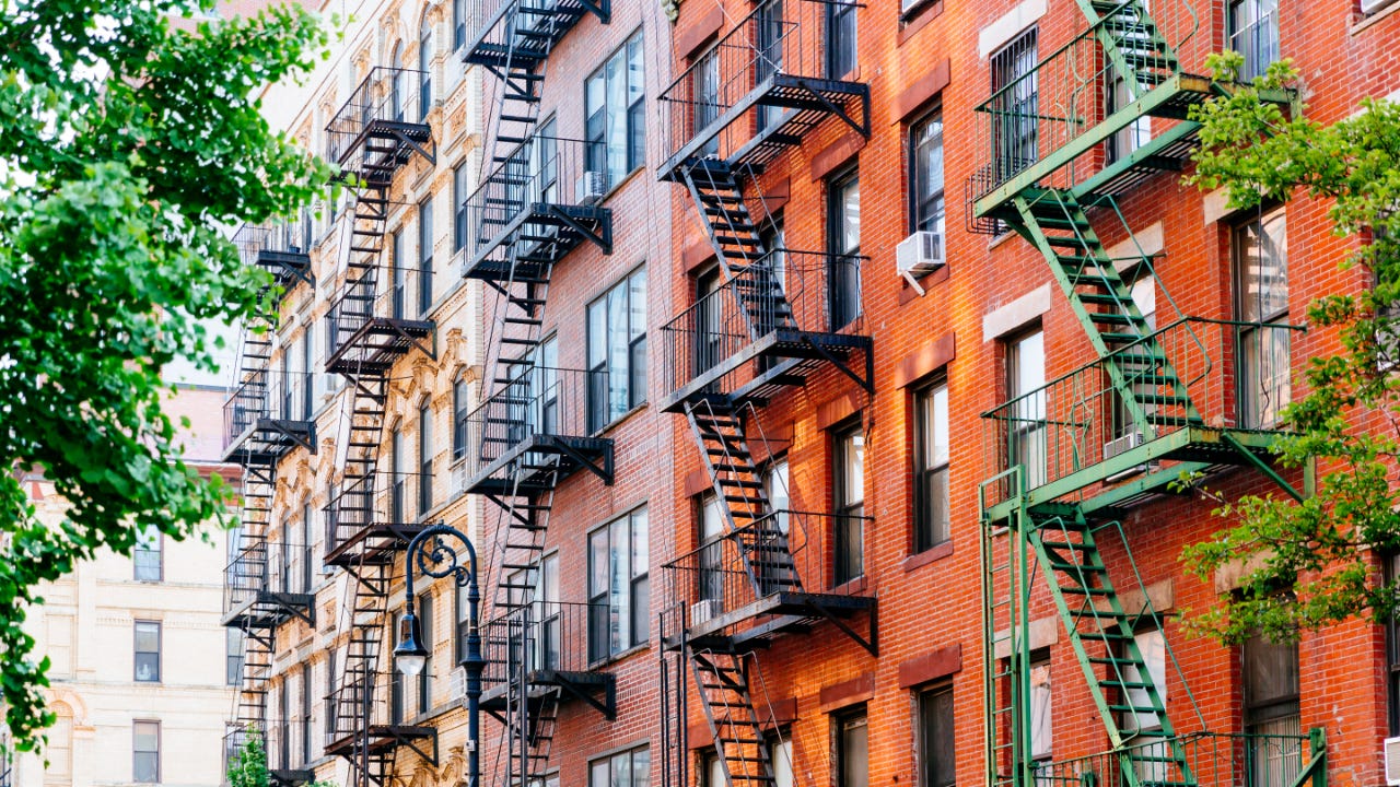 Apartment building facade with fire escapes.