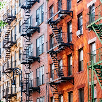Apartment building facade with fire escapes.