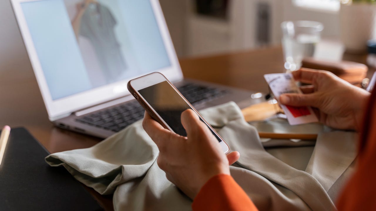 Person holding phone and credit card