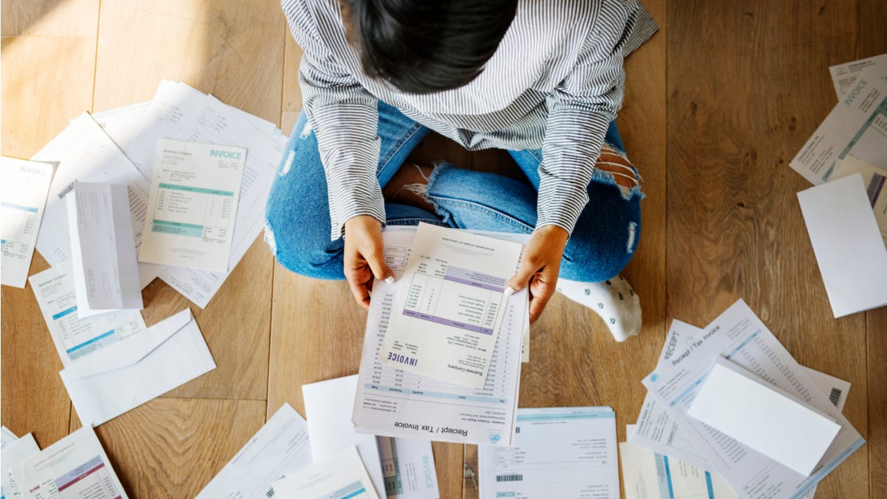 Person looks through bills on the floor