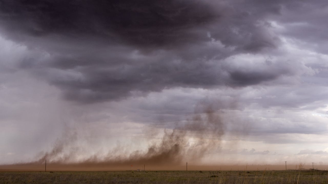 A windstorm sweeping dust up from the ground in rural Texas.
