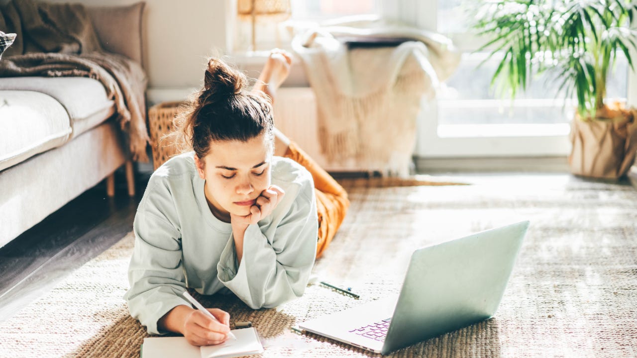 A young woman researches on her laptop.