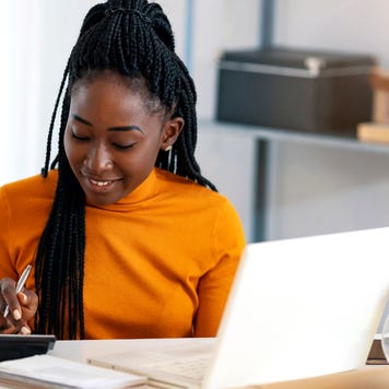 A Black woman using a calculator.