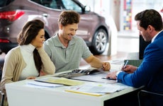 Couple signs paperwork on an auto lease