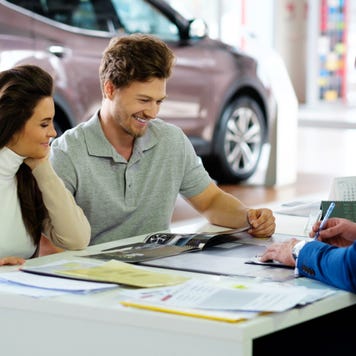 Couple signs paperwork on an auto lease