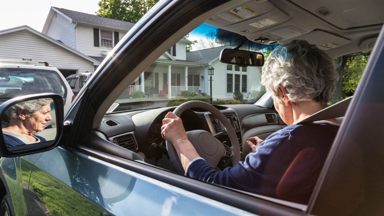 Senior woman learning car controls