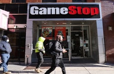 A few pedestrians pass in front of a GameStop store