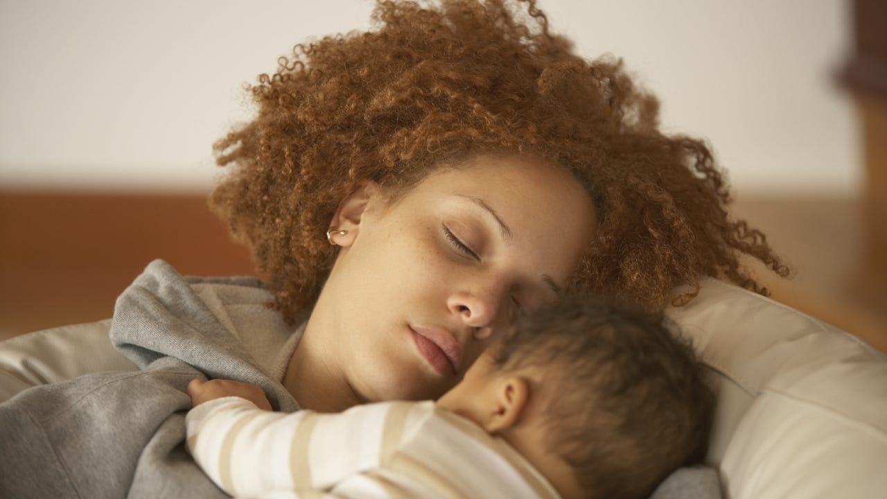 A black woman holding her child and enjoying a moment of rest.