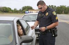 A cop has pulled a woman over and is checking her registration