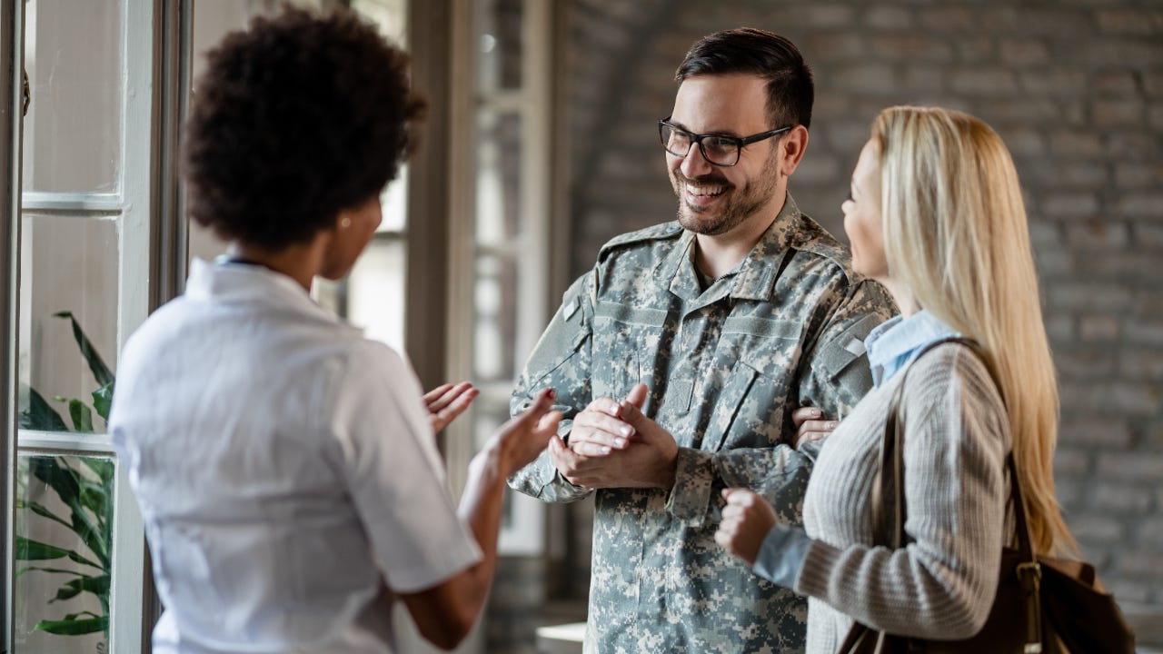 Happy army soldier and his wife communicating with a company worker