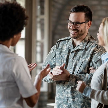 Happy army soldier and his wife communicating with a company worker