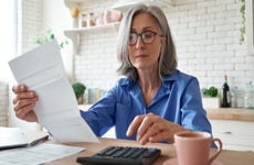 Businesswoman assessing expenses with calculator