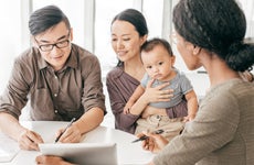 An Asian family is looking at car insurance options with an agent