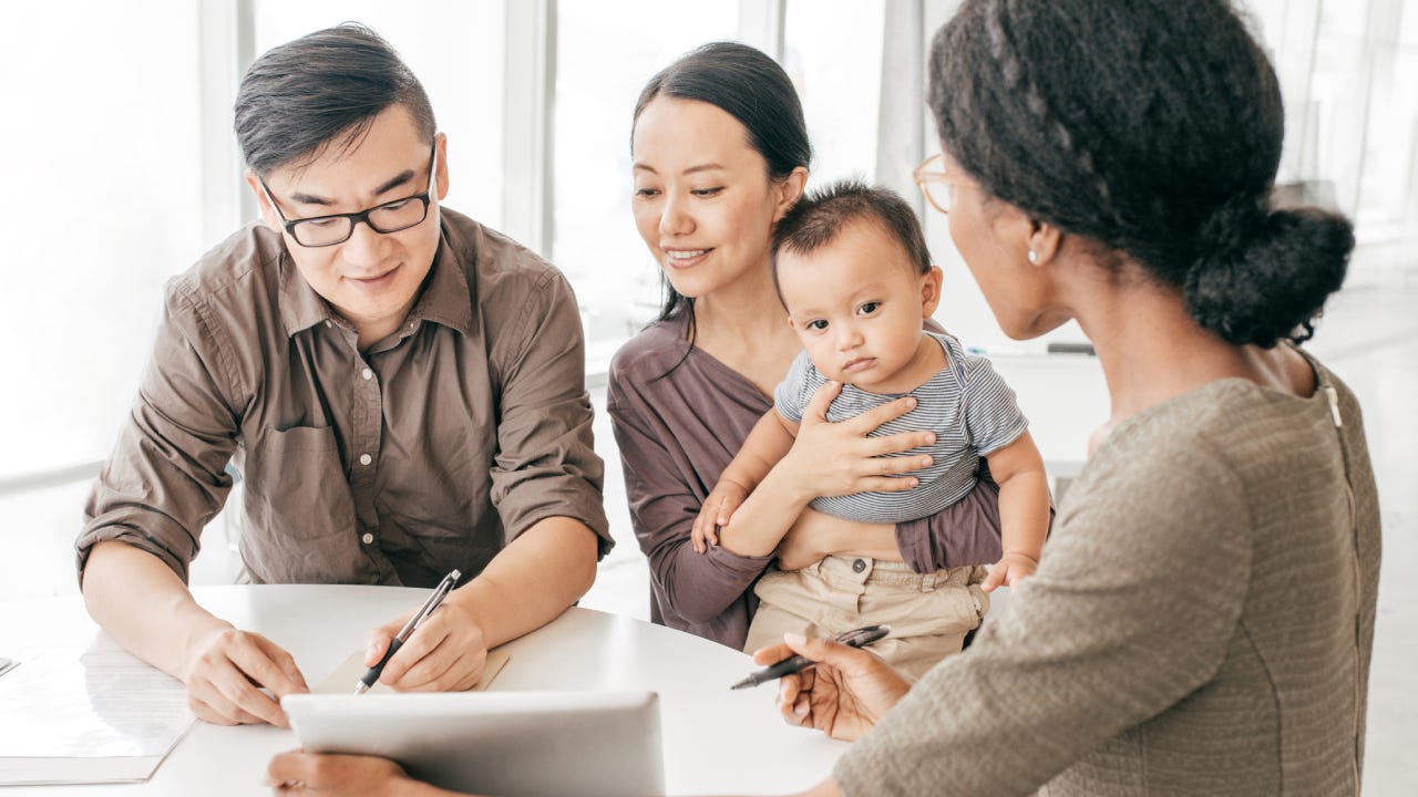 An Asian family is looking at car insurance options with an agent
