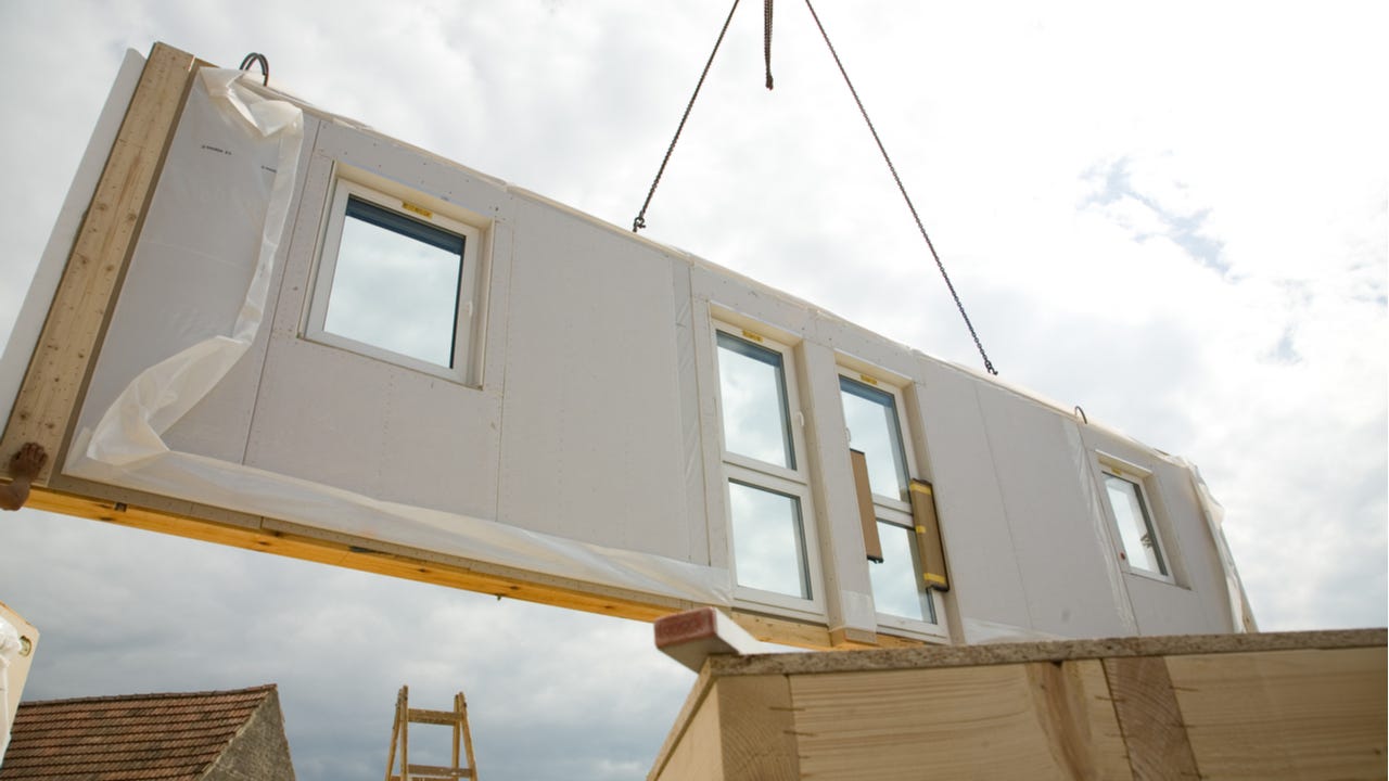 A piece of a modular home being installed via crane