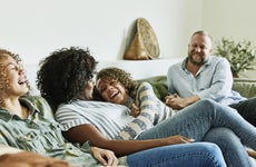 An interracial family laughing together in the living room