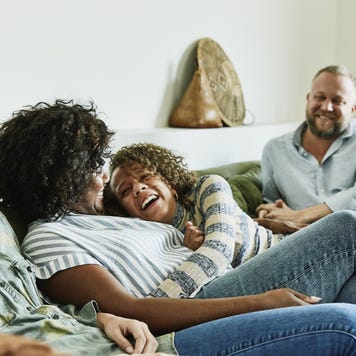 An interracial family laughing together in the living room