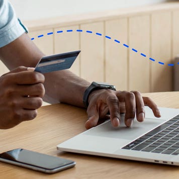 adult on his computer paying with a card