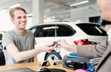 Man receives car keys at a dealership
