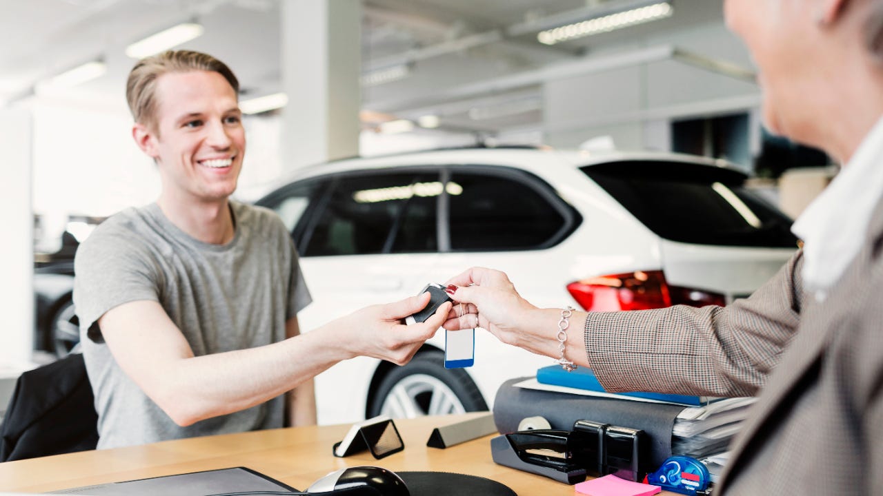 Man receives car keys at a dealership