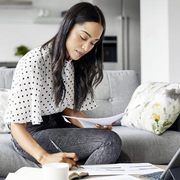 Woman analyzing documents while sitting at home