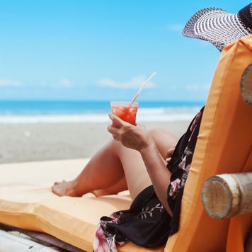 A woman lounges on the beach.