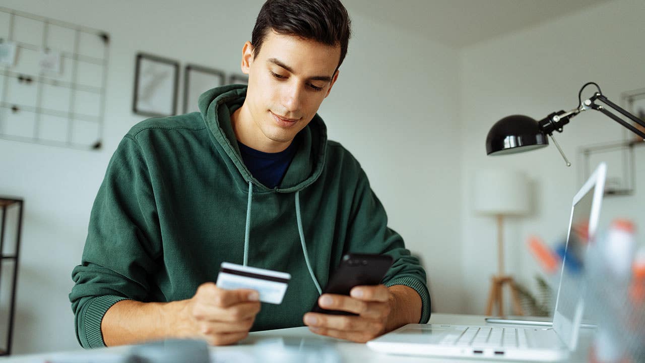 Man using credit card and mobile phone to make payment