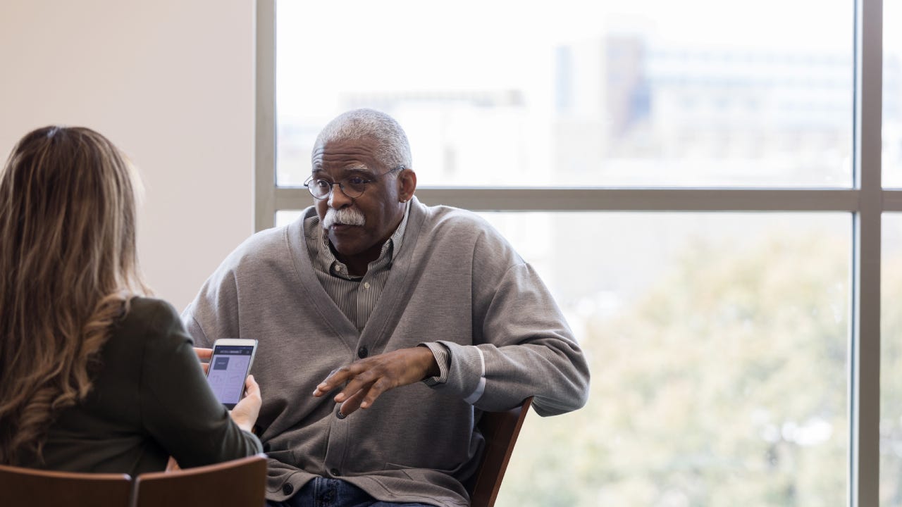 Old black man talking to a life insurance broker