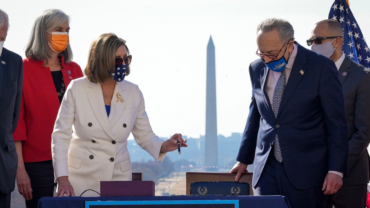 Nancy Pelosi and Chuck Schumer sign stimulus relief bill