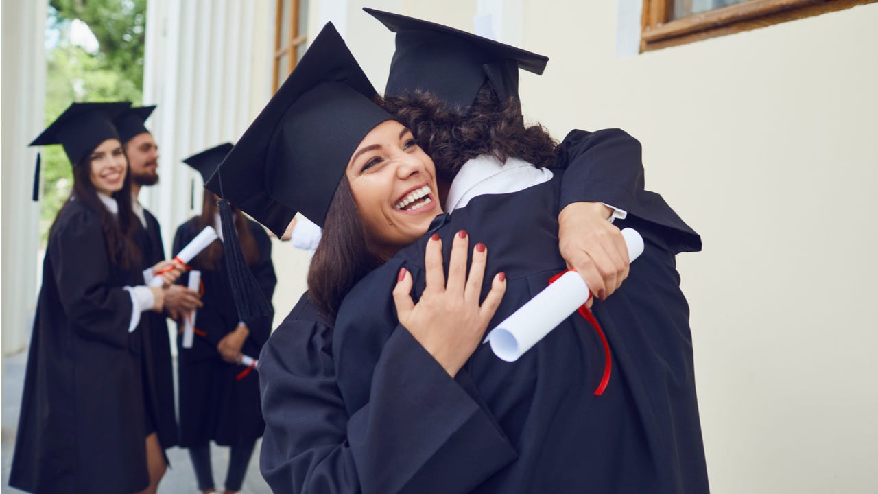College graduates embrace at graduation