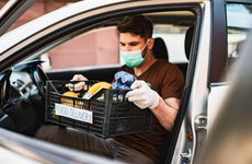 Delivery guy with protective mask and gloves delivering groceries during lockdown and pandemic