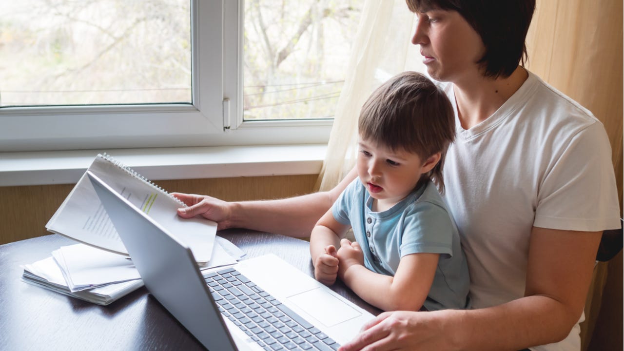 Parent working from home with child on lap