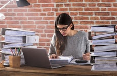 Woman works on filing taxes at her desk