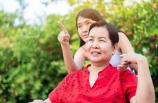 A caregiver helps an older woman.